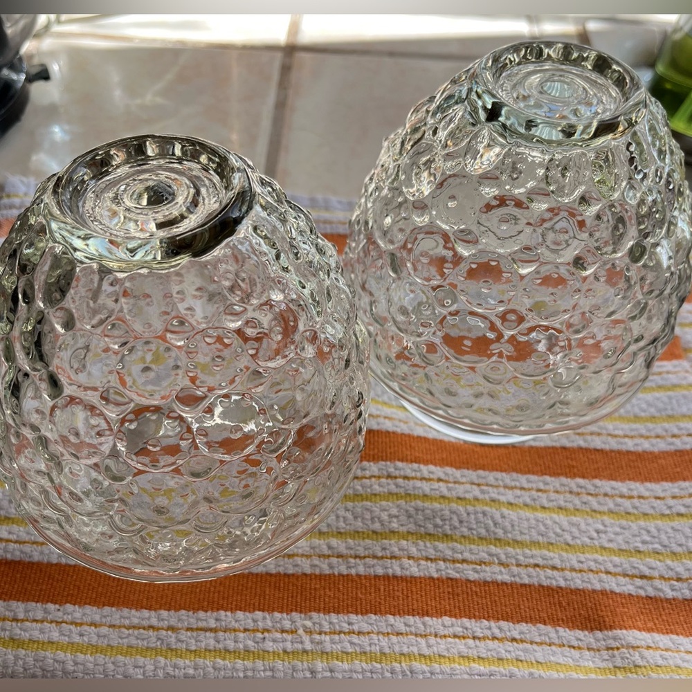 Two acorn shaped glass sconce shades.